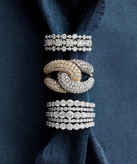 Website-2 diamond rings arranged on blue fabric
